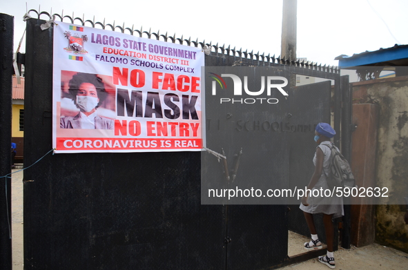 A high school student walks through a gate at Ireti Junior Grammar Schol, Ikoyi, Lagos on August 3, 2020 on the first day after resumption o...