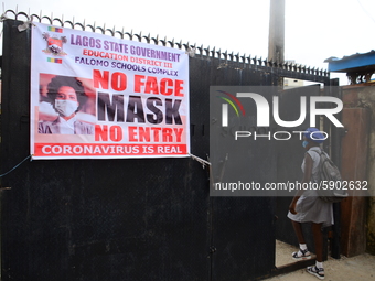 A high school student walks through a gate at Ireti Junior Grammar Schol, Ikoyi, Lagos on August 3, 2020 on the first day after resumption o...