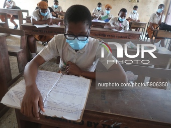 Final year students of Agidingbi Senior Grammar School, Ikeja, Lagos, Nigeria with facemasks sit in a classroom as they resume school after...