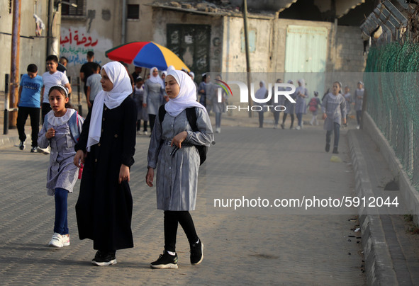 Students walk to the United-Nation run Elementary School on the first day of the new school year as Palestinians ease the coronavirus diseas...