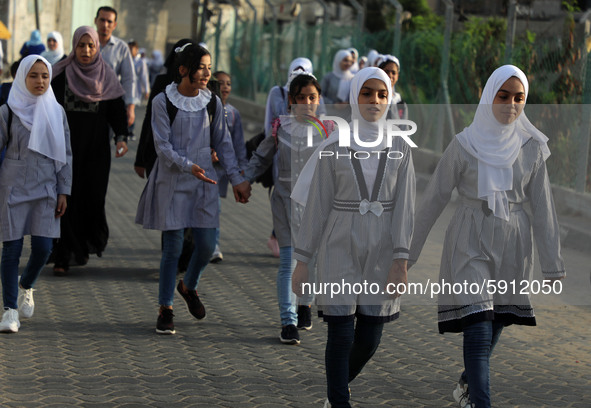 Students walk to the United-Nation run Elementary School on the first day of the new school year as Palestinians ease the coronavirus diseas...