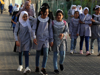 Students walk to the United-Nation run Elementary School on the first day of the new school year as Palestinians ease the coronavirus diseas...