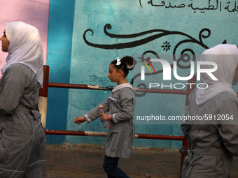 Students walk to the United-Nation run Elementary School on the first day of the new school year as Palestinians ease the coronavirus diseas...