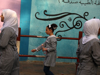 Students walk to the United-Nation run Elementary School on the first day of the new school year as Palestinians ease the coronavirus diseas...