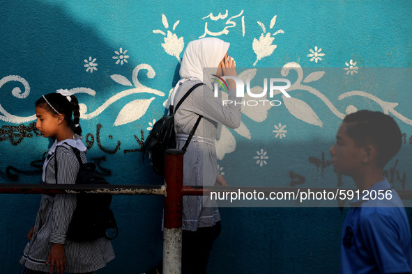 Students walk to the United-Nation run Elementary School on the first day of the new school year as Palestinians ease the coronavirus diseas...