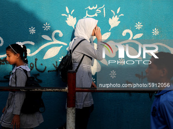 Students walk to the United-Nation run Elementary School on the first day of the new school year as Palestinians ease the coronavirus diseas...