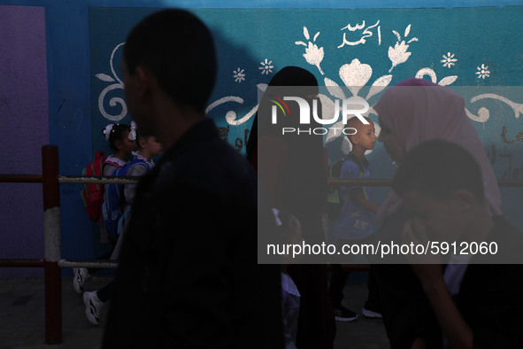 Students walk to the United-Nation run Elementary School on the first day of the new school year as Palestinians ease the coronavirus diseas...