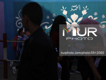 Students walk to the United-Nation run Elementary School on the first day of the new school year as Palestinians ease the coronavirus diseas...