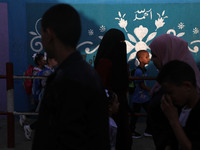 Students walk to the United-Nation run Elementary School on the first day of the new school year as Palestinians ease the coronavirus diseas...