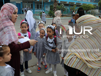 Women bring their children to the United-Nation run Elementary School on the first day of the new school year as Palestinians ease the coron...