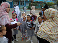 Women bring their children to the United-Nation run Elementary School on the first day of the new school year as Palestinians ease the coron...