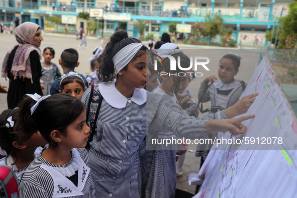 A Palestinian student looks up her name and classroom on a list at a United Nations-run school as a new school year begins as Palestinians e...