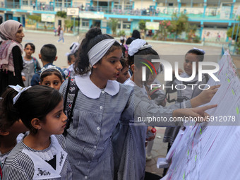 A Palestinian student looks up her name and classroom on a list at a United Nations-run school as a new school year begins as Palestinians e...