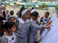 A Palestinian student looks up her name and classroom on a list at a United Nations-run school as a new school year begins as Palestinians e...