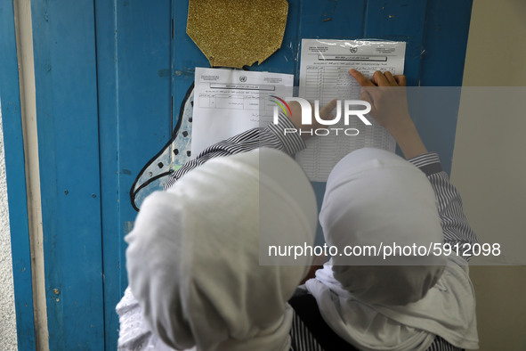 A Palestinian student looks up her name and classroom on a list at a United Nations-run school as a new school year begins as Palestinians e...