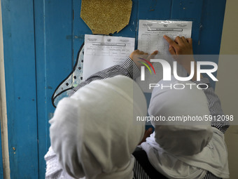 A Palestinian student looks up her name and classroom on a list at a United Nations-run school as a new school year begins as Palestinians e...