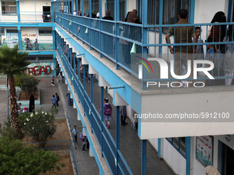 Women bring their children to the United-Nation run Elementary School on the first day of the new school year as Palestinians ease the coron...