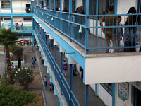 Women bring their children to the United-Nation run Elementary School on the first day of the new school year as Palestinians ease the coron...