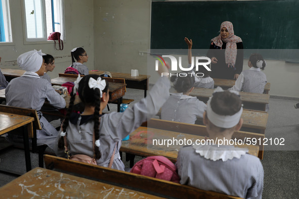 A teacher interacts with students in a classroom at a United Nations-run school as a new school year begins as Palestinians ease the coronav...