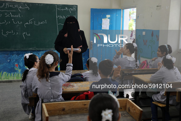 A teacher interacts with students in a classroom at a United Nations-run school as a new school year begins as Palestinians ease the coronav...