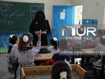 A teacher interacts with students in a classroom at a United Nations-run school as a new school year begins as Palestinians ease the coronav...