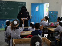 A teacher interacts with students in a classroom at a United Nations-run school as a new school year begins as Palestinians ease the coronav...