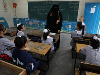 A teacher interacts with students in a classroom at a United Nations-run school as a new school year begins as Palestinians ease the coronav...