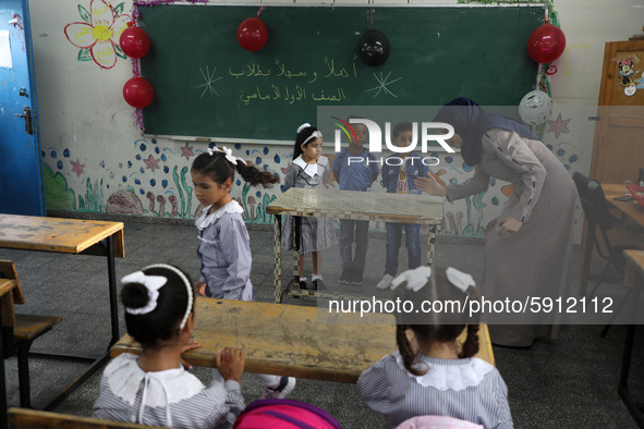 A teacher interacts with students in a classroom at a United Nations-run school as a new school year begins as Palestinians ease the coronav...