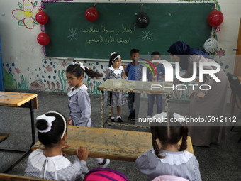 A teacher interacts with students in a classroom at a United Nations-run school as a new school year begins as Palestinians ease the coronav...