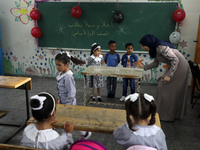 A teacher interacts with students in a classroom at a United Nations-run school as a new school year begins as Palestinians ease the coronav...