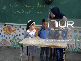 A teacher interacts with students in a classroom at a United Nations-run school as a new school year begins as Palestinians ease the coronav...