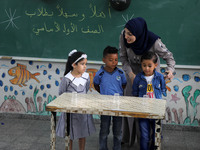 A teacher interacts with students in a classroom at a United Nations-run school as a new school year begins as Palestinians ease the coronav...