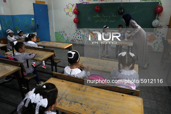 A teacher interacts with students in a classroom at a United Nations-run school as a new school year begins as Palestinians ease the coronav...