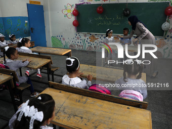 A teacher interacts with students in a classroom at a United Nations-run school as a new school year begins as Palestinians ease the coronav...