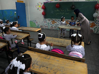 A teacher interacts with students in a classroom at a United Nations-run school as a new school year begins as Palestinians ease the coronav...