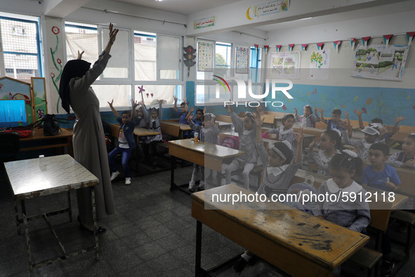 A teacher interacts with students in a classroom at a United Nations-run school as a new school year begins as Palestinians ease the coronav...