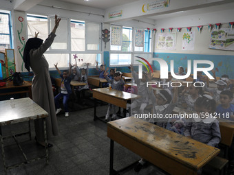 A teacher interacts with students in a classroom at a United Nations-run school as a new school year begins as Palestinians ease the coronav...