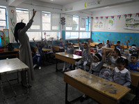 A teacher interacts with students in a classroom at a United Nations-run school as a new school year begins as Palestinians ease the coronav...