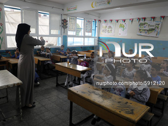 A teacher interacts with students in a classroom at a United Nations-run school as a new school year begins as Palestinians ease the coronav...