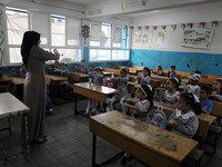 A teacher interacts with students in a classroom at a United Nations-run school as a new school year begins as Palestinians ease the coronav...