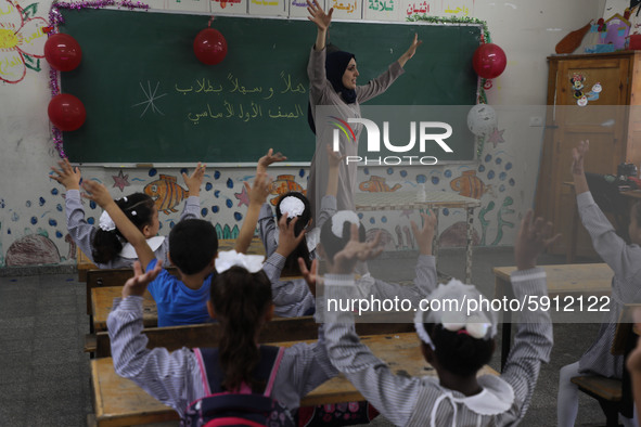 A teacher interacts with students in a classroom at a United Nations-run school as a new school year begins as Palestinians ease the coronav...