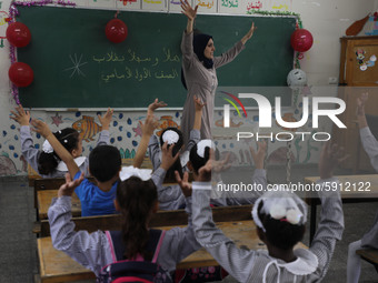 A teacher interacts with students in a classroom at a United Nations-run school as a new school year begins as Palestinians ease the coronav...