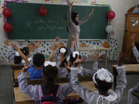 A teacher interacts with students in a classroom at a United Nations-run school as a new school year begins as Palestinians ease the coronav...