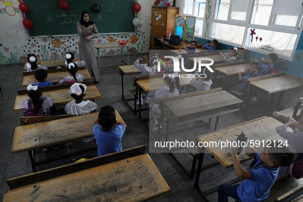 A teacher interacts with students in a classroom at a United Nations-run school as a new school year begins as Palestinians ease the coronav...