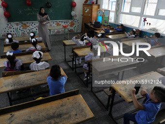 A teacher interacts with students in a classroom at a United Nations-run school as a new school year begins as Palestinians ease the coronav...