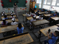 A teacher interacts with students in a classroom at a United Nations-run school as a new school year begins as Palestinians ease the coronav...