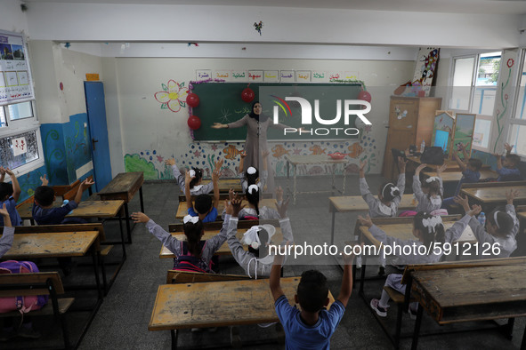 A teacher interacts with students in a classroom at a United Nations-run school as a new school year begins as Palestinians ease the coronav...