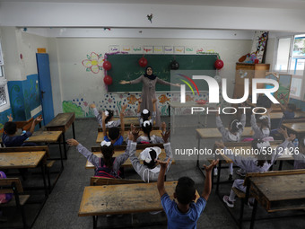 A teacher interacts with students in a classroom at a United Nations-run school as a new school year begins as Palestinians ease the coronav...