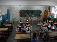 A teacher interacts with students in a classroom at a United Nations-run school as a new school year begins as Palestinians ease the coronav...