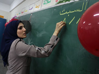 A teacher interacts with students in a classroom at a United Nations-run school as a new school year begins as Palestinians ease the coronav...